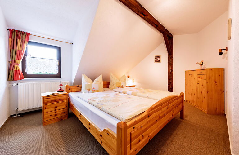 Schlafzimmer mit Doppelbett und Fachwerkbalken
